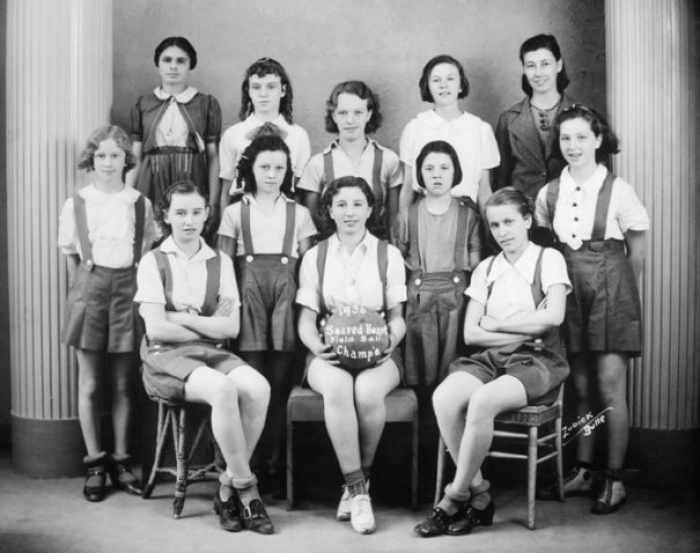 "Sacred Heart Field Ball Champ's, 1936, Butte, Montana. 1st Row - Ann McEnaney, Mary Sutey (Cap't) and Mary Dika 2nd Row - Betty Garland, Ann J. Spencer, Helen Susak, and Betty Jo Rogers 3rd Row - Catherine Murray, Marrion Stanaway, Rosemarie Susak and Phyllis Ruthledge Irene Pappas (Coach)"